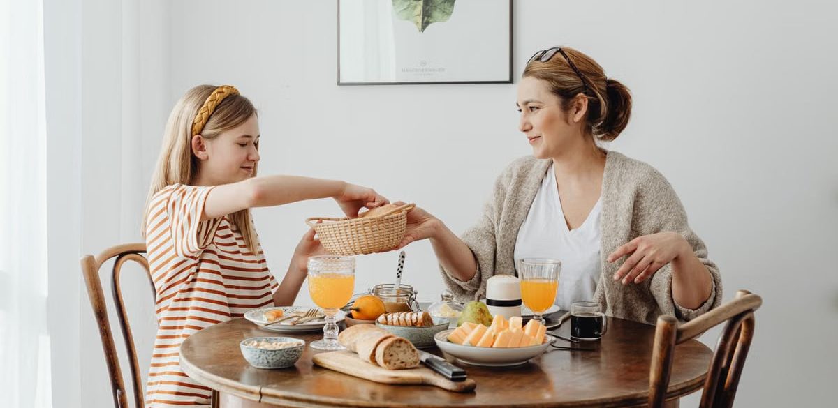 A warm family breakfast with mother and daughter sharing a meal in a cozy dining area.