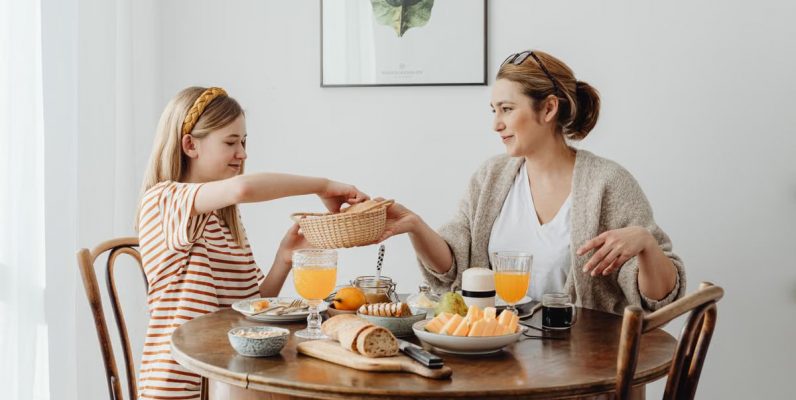 A warm family breakfast with mother and daughter sharing a meal in a cozy dining area.