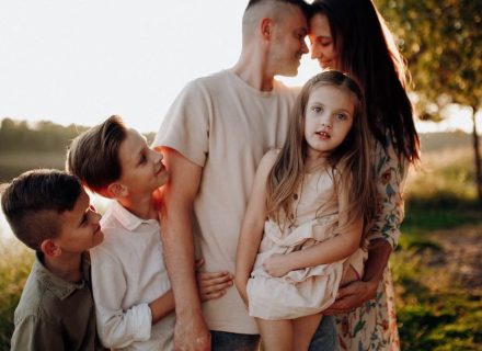 Family enjoying quality time together outdoors by the lake during sunset.